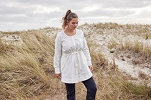 blonde Frau mit blauem T-Shirt und grauer Strickjacke